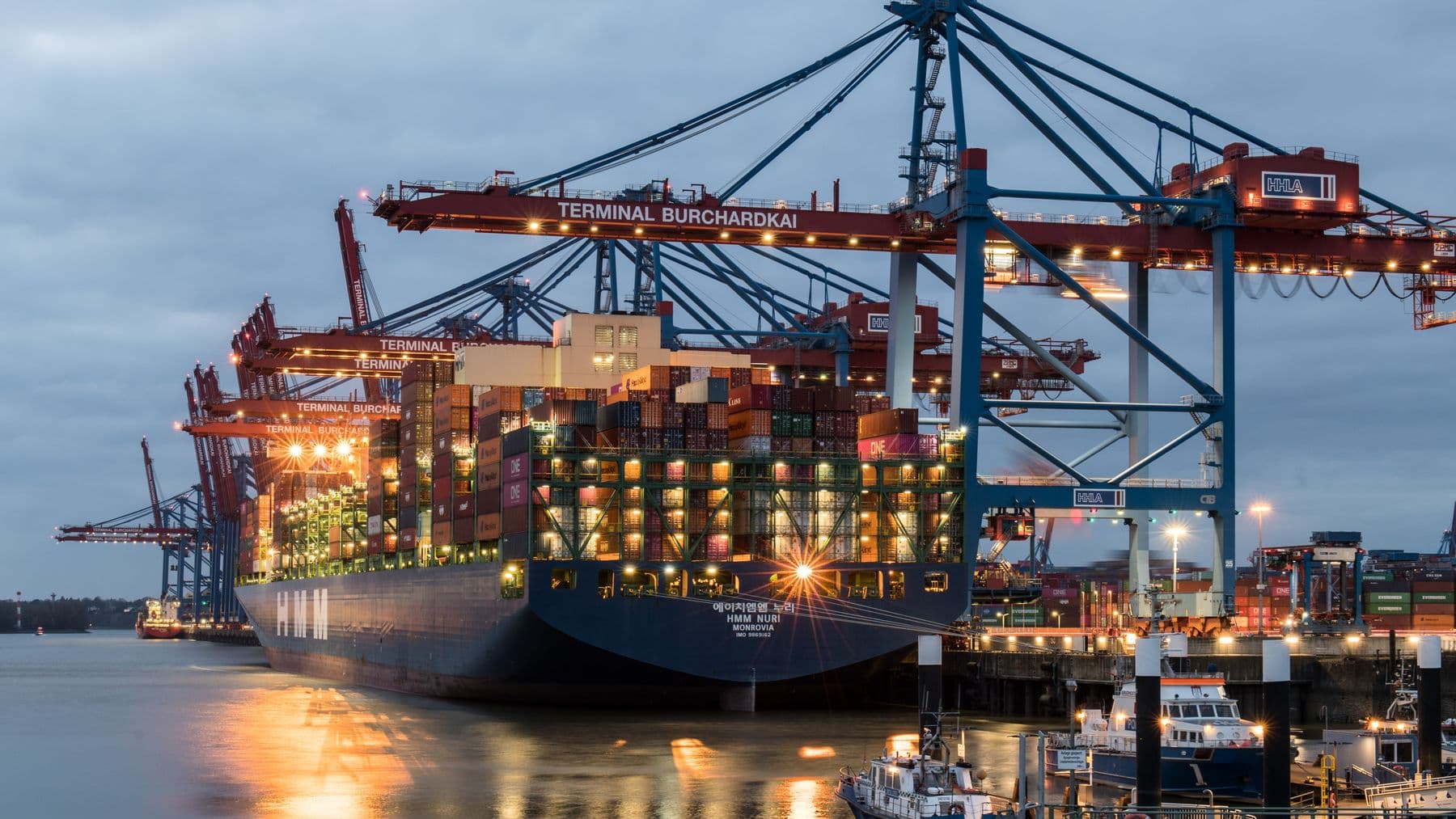 Container ships moored at Terminal Burchardkai in Hamburg, Germany during evening hours.